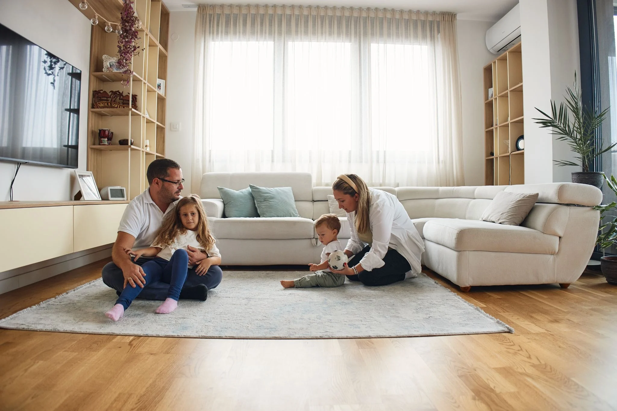 Family of four playing with their children.